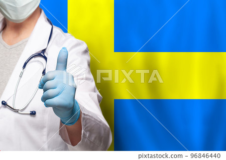 Swedish doctor's hand showing thumb up positive gesture on flag of Sweden background Swedish doctor's hand showing thumb up positive gesture on flag of Sweden background 96846440