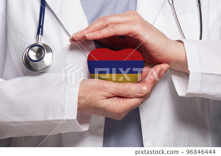Armenian doctor holding heart with flag of Armenia background.  96846444