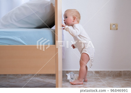 Caucasian baby girl playing hide and seek with her parents. Caucasian baby girl playing hide and seek with her parents. 96846991