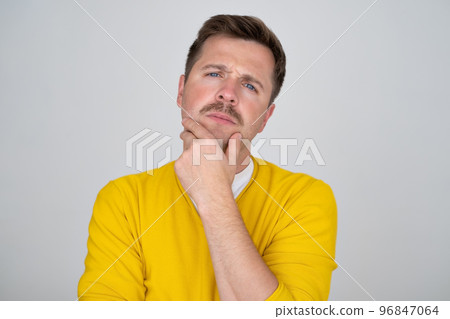 Thoughtful caucasian young man touch chin with finger thinking Thoughtful caucasian young man touch chin with finger thinking 96847064