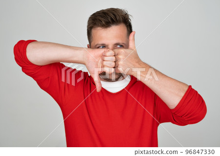 Mature caucasian man making good-bad sign showing thumb up and down.  96847330