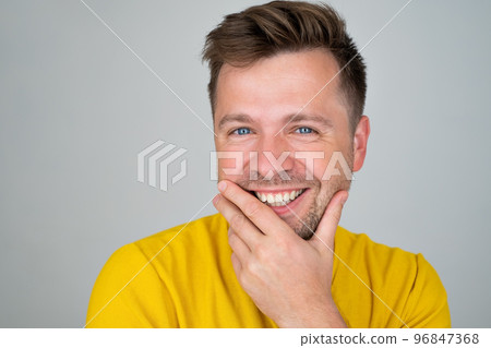 Handsome young man smiling while standing isolated on white background Handsome young man smiling while standing isolated on white background 96847368