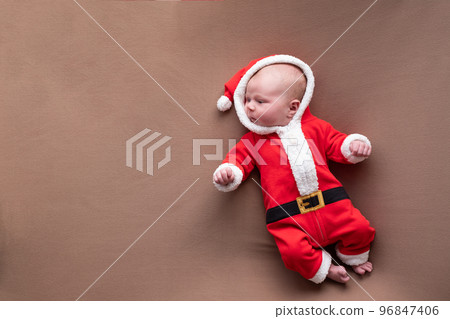 Newborn girl dressed in santa claus costume yawning being tired. Newborn girl dressed in santa claus costume yawning being tired. 96847406
