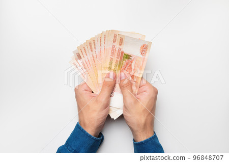 Hands holding five thousand rubles. Male hands holding a lot of money on a white background 96848707