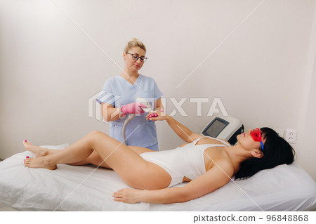 A cosmetologist performs a laser hair removal procedure in the office A cosmetologist performs a laser hair removal procedure in the office 96848868