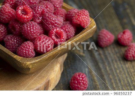 The harvest of red ripe raspberries is on the board The harvest of red ripe raspberries is on the board 96850237