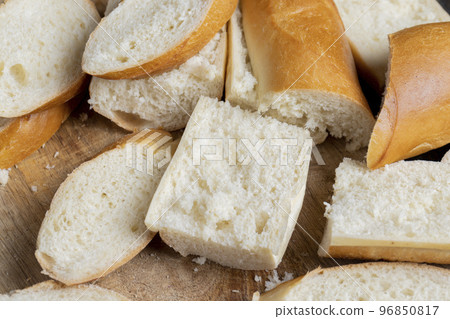 a wheat baguette cut into pieces, close up 96850817