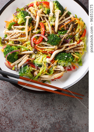plate of stir fried vegetables with shimeji beech mushrooms closeup. Vertical top view plate of stir fried vegetables with shimeji beech mushrooms closeup. Vertical top view 96851575