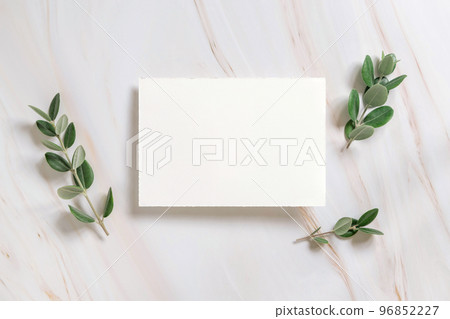 Horizontal card on a marble table decorated with eucalyptus branches top view, Wedding mockup 96852227