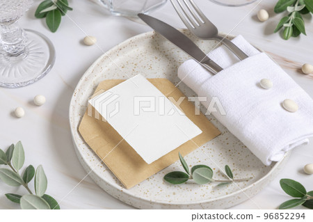 Elegant Table setting with a card decorated with eucalyptus branches close up, Wedding mockup 96852294