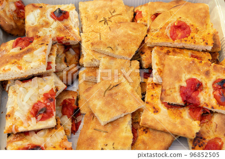 Freshly baked homemade apulian focaccia with tomatoes cut in slices top view 96852505