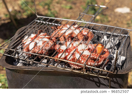 Fresh octopuses on the charcoal grill, Italy. Traditional Mediterranean cuisine. 96852507