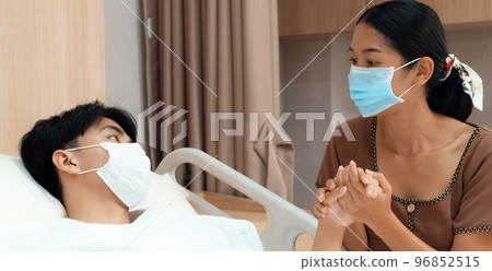 Young patient with attentive visitor in hospital's sterile recovery room. 96852515