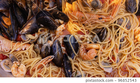 Italian spaghetti allo scoglio, pasta with seafood and tomatoes close up in a frying pan Italian spaghetti allo scoglio, pasta with seafood and tomatoes close up in a frying pan 96852543