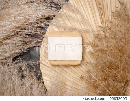 Soap bar with blank label on dried palm leaf near pampas grass top view. Label Mockup 96852605