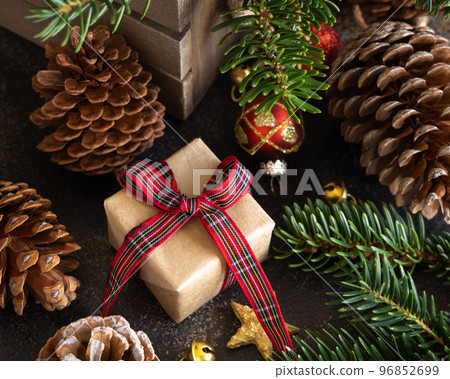 Wrapped gift boxes between Christmas decorations, pine cones and green fir branches 96852699