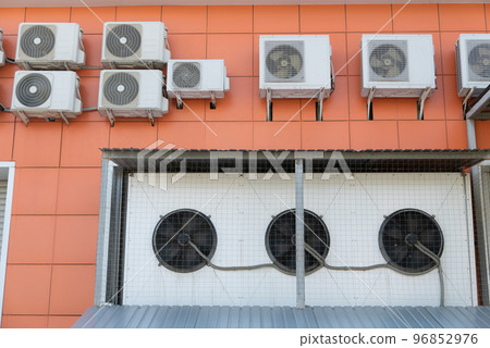 Air conditioner compressor installed outdoors orange wall 96852976