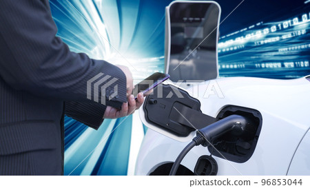 Progressive man charge electric car with technology background of binary code. 96853044
