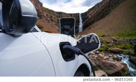 Progressive concept of energy sustainability by EV car in the waterfall. Progressive concept of energy sustainability by EV car in the waterfall. 96853160