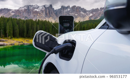 Progressive travel concept by EV car in remote mountain with charging station. 96853177