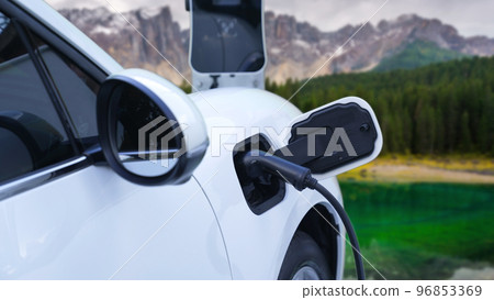 Progressive travel concept by EV car in remote mountain with charging station. 96853369