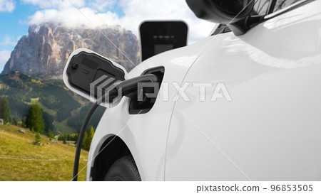 Progressive travel concept by EV car in remote mountain with charging station. Progressive travel concept by EV car in remote mountain with charging station. 96853505