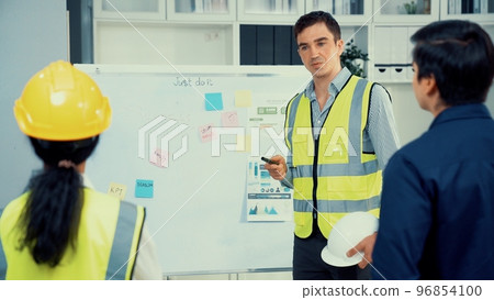 A team of investor and competent engineers brainstorming on the whiteboard. 96854100