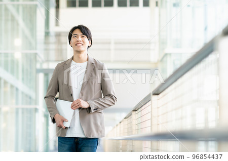Young businessman walking in the office Young businessman walking in the office 96854437