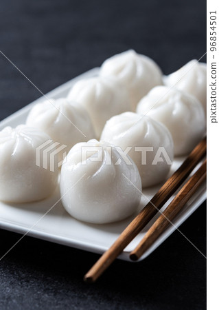 Steamed dumplings on black slate background Steamed dumplings on black slate background 96854501