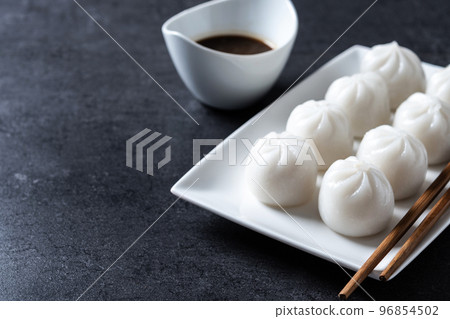 Steamed dumplings and soy sauce on black slate background 96854502