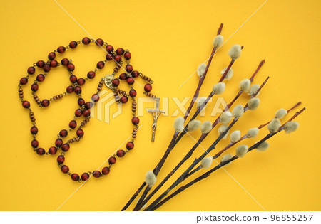 Dry willow branches and rosary wooden prayer beads crucifix on yellow background. Palm Sunday spring holiday. Holy week christian religious concept. Flatlay, lay out, top view 96855257