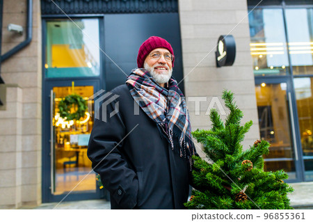 trendy old good-looking man walking in sity street at winter near modern building 96855361