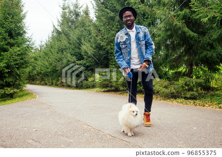 afro man hugging his fluffy spitz in park afro man hugging his fluffy spitz in park 96855375