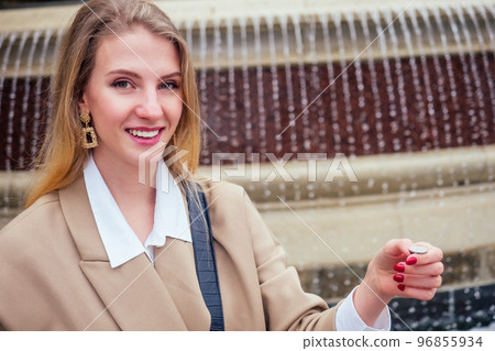 Young blonde woman makes a wish at the Prague Chezh Fountain Young blonde woman makes a wish at the Prague Chezh Fountain 96855934