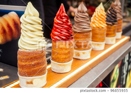 woman with an appetite eats a traditional Czech sweet Trdelnik in Prague street woman with an appetite eats a traditional Czech sweet Trdelnik in Prague street 96855935