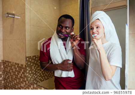 african american man and woman with a towel wrapped on her head together clean teeth 96855978