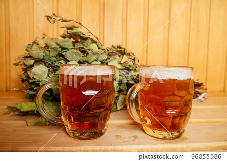 redhaired ginger woman steaming in the bathhouse with russian bunch broom drinking beers.she enjoying the sauna finnish spa 96855986