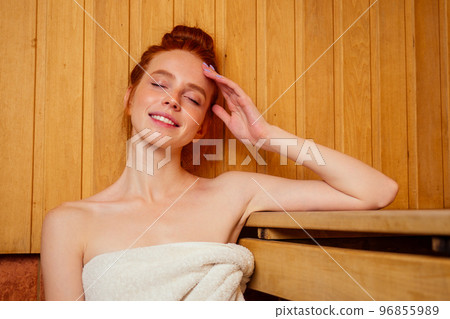 redhaired ginger woman relaxing in a russian banya sauna pampering herself,self-love concept 96855989
