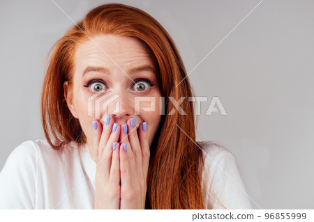 redhair ginger woman in white cotton t-shirt fingers crossed wishing the best in studio gray background redhair ginger woman in white cotton t-shirt fingers crossed wishing the best in studio gray background 96855999
