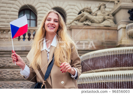 Young female tourist with czech flag wawing near fountain Wenceslas Square 96856003