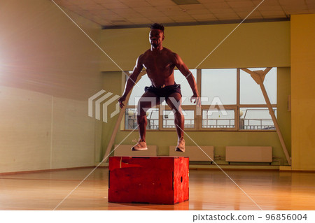 afro man doing exercise with a fit box in a gym 96856004