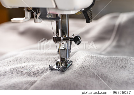 Modern sewing machine and gray fabric. Sewing process, handmade, hobby, DIY, business, repair 96856027