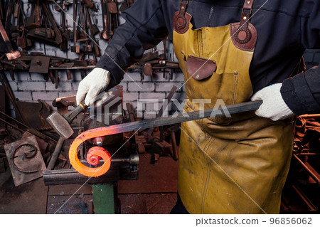 handsome african american blacksmith male worker working in workshop,wearing leather apron 96856062