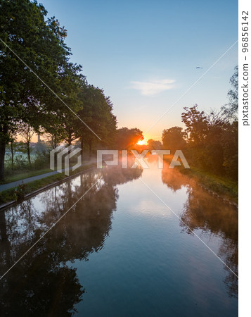 Panorama of dramatic and colorful sky over Fields, trees and River or canal from a drone during Panorama of dramatic and colorful sky over Fields, trees and River or canal from a drone during 96856142