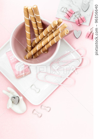 Desktop flat lay of office stationery items with copy space on a pink desktop 96856640