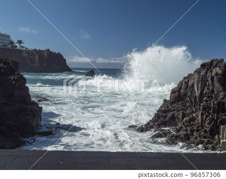 View of natural rock swimming pool Charco de Isla Cangrejo in the Atlantic Ocean in Los Gigantes, Tenerife, Canary islands, Spain. Sunny winter day. View of natural rock swimming pool Charco de Isla Cangrejo in the Atlantic Ocean in Los Gigantes, Tenerife, Canary islands, Spain. Sunny winter day. 96857306