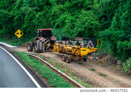 the tractor pulls out of the field onto the asphalt road the tractor pulls out of the field onto the asphalt road 96857592