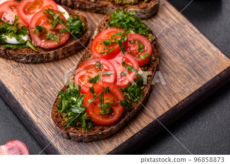 Tasty bruschetta with tomatoes, mozzarella, basil, spices and herbs 96858873