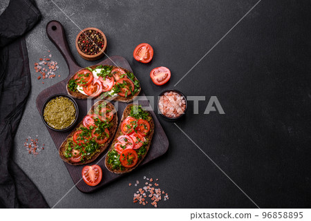 Tasty bruschetta with tomatoes, mozzarella, basil, spices and herbs Tasty bruschetta with tomatoes, mozzarella, basil, spices and herbs 96858895