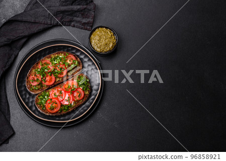 Tasty bruschetta with tomatoes, mozzarella, basil, spices and herbs 96858921